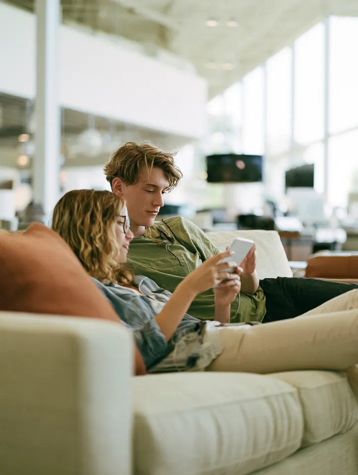 Young couple relaxing on a sofa in a furniture showroom